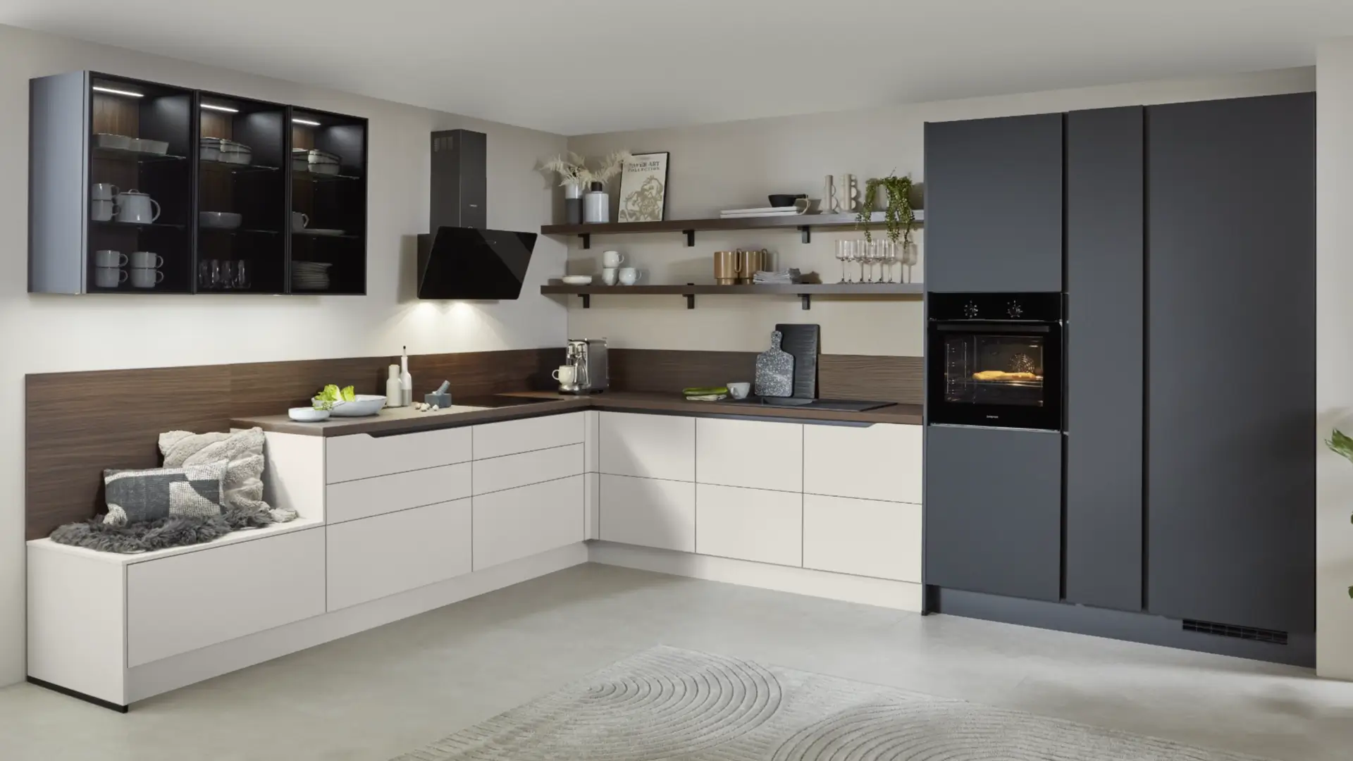 Moderne U-förmige Küche mit hellen Schränken, schwarzen Oberschränken mit Glasfront, integriertem Ofen und Dunstabzugshaube, Küchenbank mit Kissen, offenen Regalen und Dekorationen.